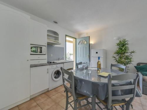 eine Küche und ein Esszimmer mit einem Tisch und Stühlen in der Unterkunft Apartment Le Jardin d'Artemis-2 by Interhome in Saint-Tropez