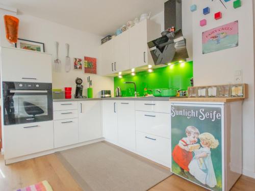 kuchnia z białymi szafkami i zielonymi ścianami w obiekcie Apartment Milli by Interhome w mieście Wenns
