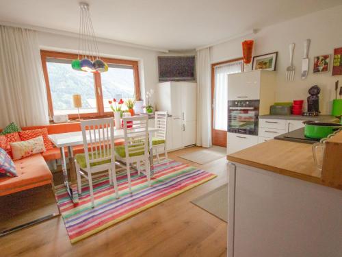 kuchnia i salon ze stołem i krzesłami w obiekcie Apartment Milli by Interhome w mieście Wenns
