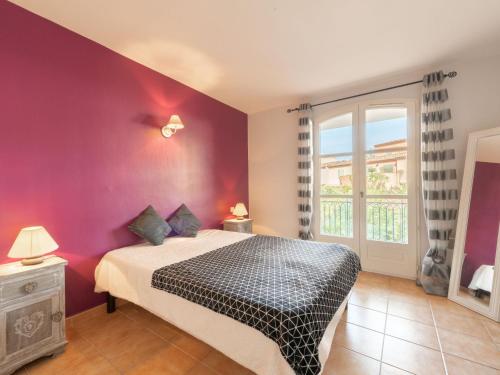 - une chambre avec un lit et un mur violet dans l'établissement Apartment Le Clos des Vignes by Interhome, à La Môle