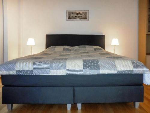 - une chambre avec un lit bleu et deux lampes dans l'établissement Apartment Fasan by Interhome, à Warwerort