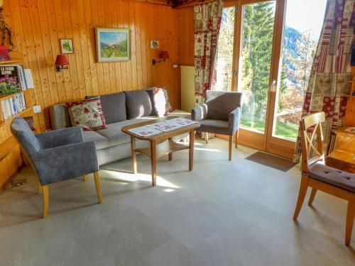 een woonkamer met een bank, 2 stoelen en een tafel bij Apartment Haimavati by Interhome in Verbier