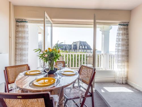 uma sala de jantar com mesa e cadeiras e uma grande janela em Apartment Le Parc de La Jacotte-6 by Interhome em Trouville-sur-Mer
