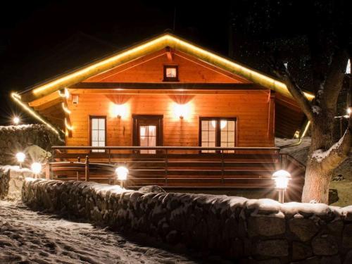 a log cabin with lights in the snow at night at Holiday Home Bečov nad Teplou 2 by Interhome in Bečov nad Teplou