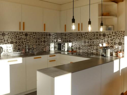 une cuisine avec des placards blancs et un comptoir noir dans l'établissement Apartment Royal 4 by Interhome, à Verbier