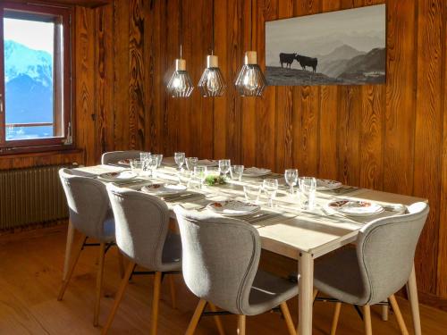 einen langen Tisch mit Stühlen und Weingläsern darauf in der Unterkunft Apartment Royal 4 by Interhome in Verbier