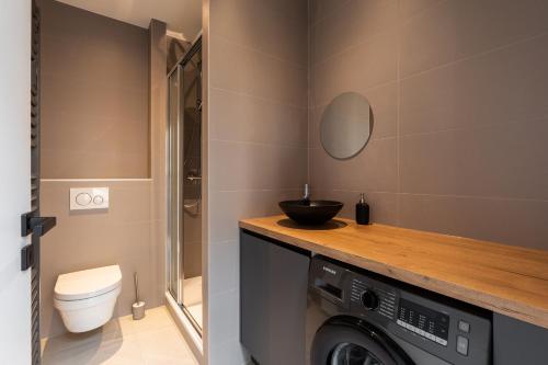 a bathroom with a toilet and a washer and dryer at DIFY Bellecour - Centre Ville in Lyon