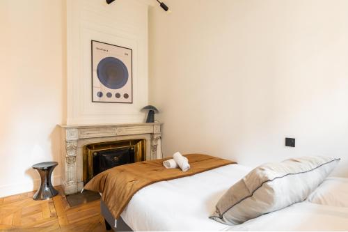 a bedroom with two beds and a fireplace at DIFY Bellecour - Centre Ville in Lyon
