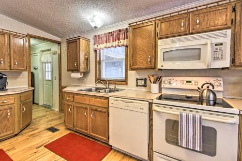 a kitchen with white appliances and wooden cabinets at Cozy Crosby Cabin Near Serpent Lake and Main St in Crosby