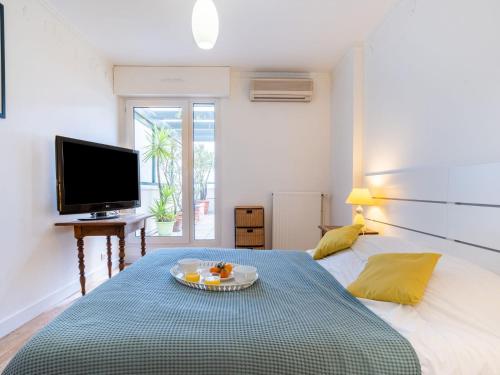 una camera da letto con un letto e un vassoio di frutta; di Apartment Les Jardins Victoria-1 by Interhome a Biarritz