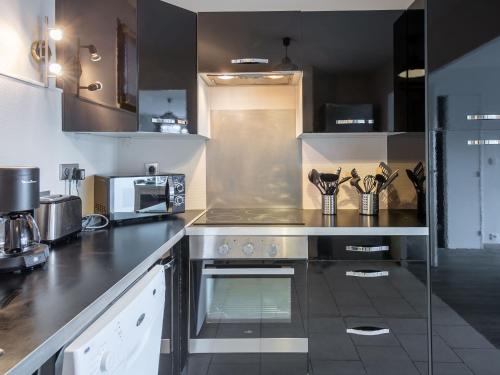 une cuisine avec une cuisinière et un micro-ondes dans l'établissement Apartment Les grands jardins by Interhome, à Saint-Malo