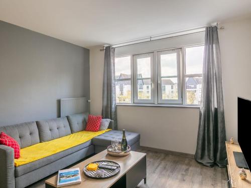 a living room with a couch and a large window at Apartment Les grands jardins by Interhome in Saint Malo
