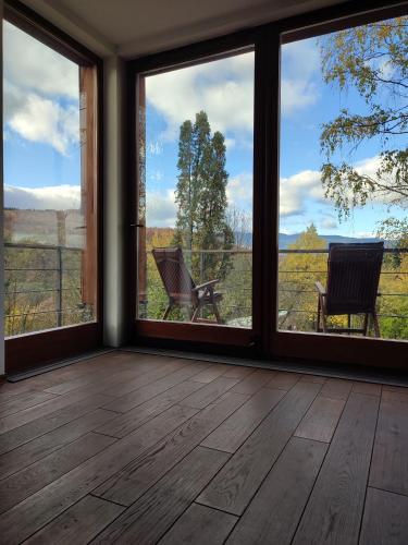 a room with large windows with a view of a field at Šumarak Lodge in Sarajevo