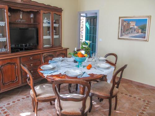 comedor con mesa con sillas y TV en Holiday Home Arietta VLO150 by Interhome, en Pantasina