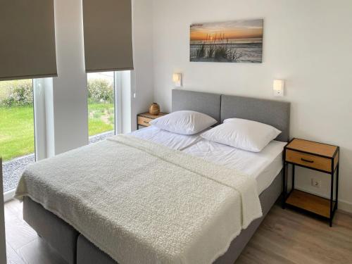 a bedroom with a large bed with two pillows at Holiday Home Ruisweg 83 by Interhome in Wemeldinge