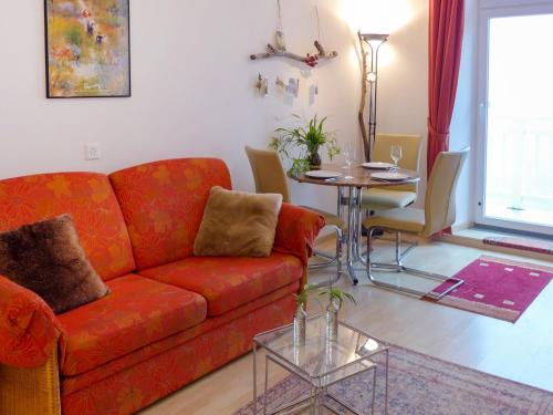 ein Wohnzimmer mit einem roten Sofa und einem Tisch in der Unterkunft Apartment Alpes et Lac 28 by Interhome in Champex