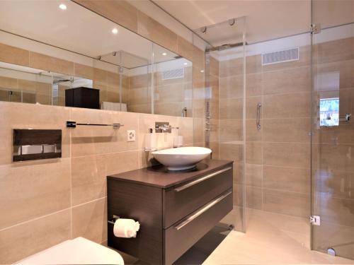 a bathroom with a sink and a glass shower at Apartment Chesa Piz Mezdi - St- Moritz by Interhome in St. Moritz