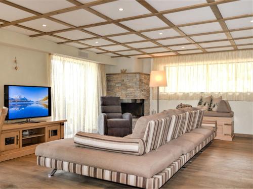 ein Wohnzimmer mit einem Sofa und einem Flachbild-TV in der Unterkunft Apartment Chesa Piz Mezdi - St- Moritz by Interhome in St. Moritz