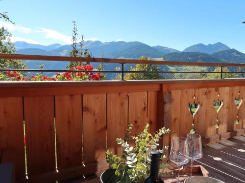 a table with wine glasses on a deck with a view at Chalet Feldkasten by Interhome in Dorf