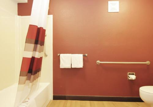 a bathroom with a shower curtain and a toilet at Red Roof PLUS Chicago - Hoffman Estates in Hoffman Estates
