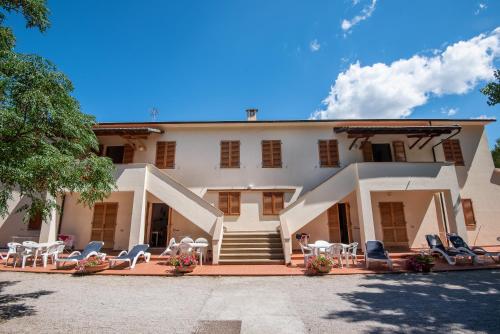 budynek z krzesłami i stołami przed nim w obiekcie Ghiacci Vecchi Residence w mieście Venturina Terme