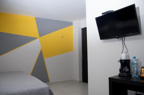 a room with a bed and a flat screen tv at Hotel HAUS Express in Orizaba