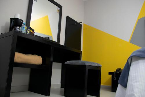 a black dresser with a mirror and a stool at Hotel HAUS Express in Orizaba
