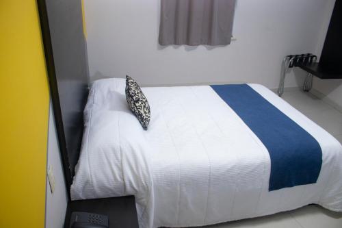 a bedroom with a bed with a blue and white blanket at Hotel HAUS Express in Orizaba