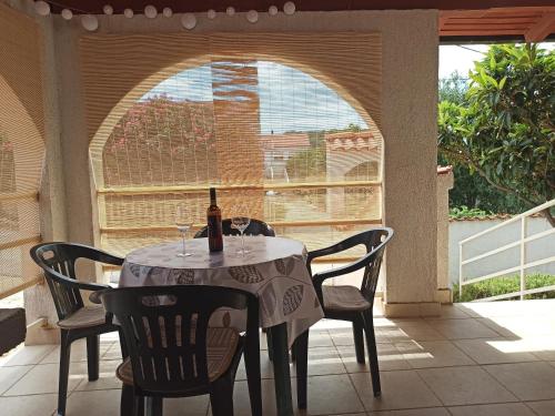 a table with a bottle of wine sitting on a patio at Apartments Kornati in Ždrelac