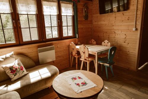 a living room with a table and a dining room at Sielska Chyża in Rzepedż