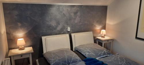 two beds in a room with two lamps on the wall at Ferienwohnung Wildgatter in Grafenwiesen