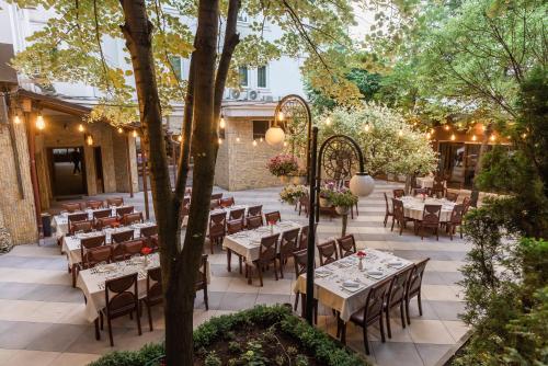 a restaurant with tables and chairs in a courtyard at Hotel Afa in Pristina