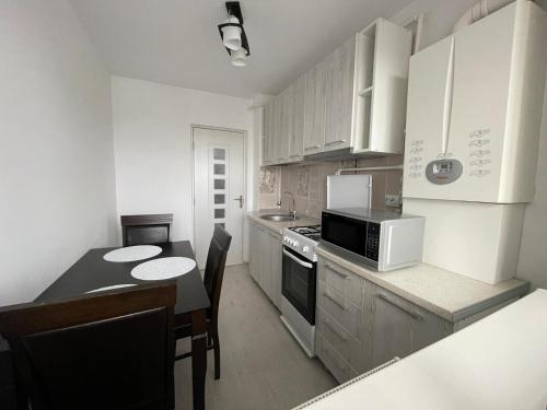 eine kleine Küche mit einem Tisch und einer Mikrowelle in der Unterkunft Elite Apartment in Târgovişte