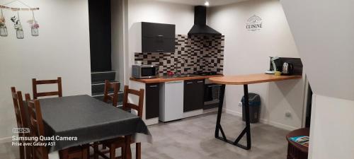 une petite cuisine avec une table et une cuisinière dans l'établissement Nouveau à Cuisery appartement 70m2, à Cuisery