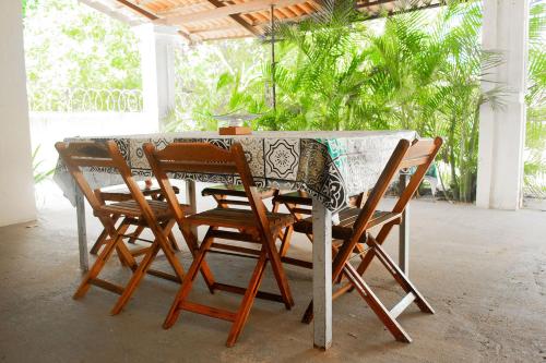 a table with four chairs around it in a room at Casa perto da Praia Canto da Barra em Fortim CE in Fortim