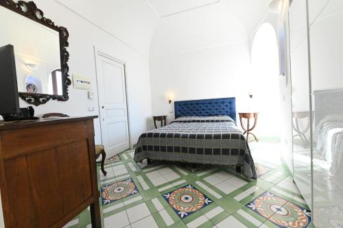 a bedroom with a bed and a mirror at Hotel Croce Di Amalfi in Amalfi