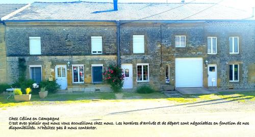Mazerny的住宿－CHEZ CELINE en campagne，旧砖楼,有两个白色车库门