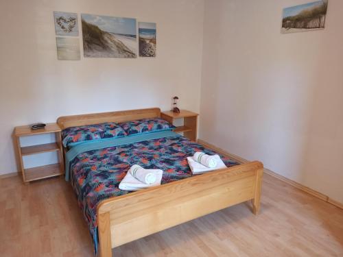 a bedroom with a bed with two white shoes on it at Apartments Kornati in Ždrelac