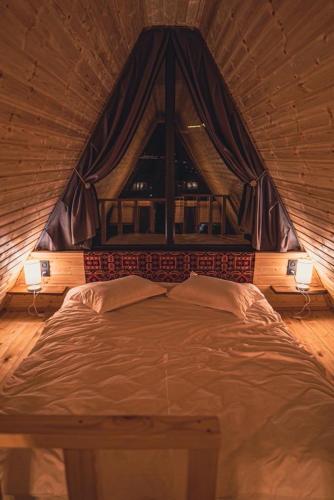 a large bed in a room with a window at Little Wood House Gergeti in Stepantsminda
