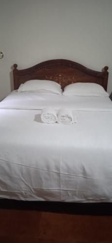 a white bed with white sheets and pillows on it at NIDHIVANA FARMS & RESORT, bakrebail-salethoor rd, Mangalore in Mangalore
