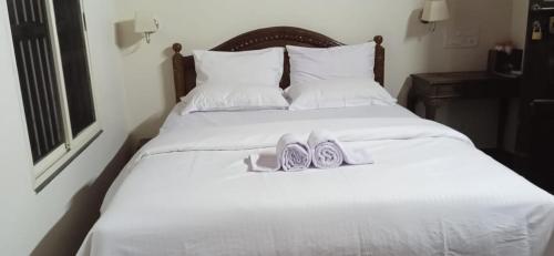 a pair of shoes sitting on top of a bed at NIDHIVANA FARMS & RESORT, bakrebail-salethoor rd, Mangalore in Mangalore
