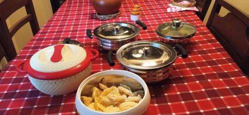 a table with several pots and a bowl of potato chips at NIDHIVANA FARMS & RESORT, bakrebail-salethoor rd, Mangalore in Mangalore