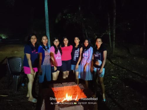 a group of women standing in front of a fire at NIDHIVANA FARMS & RESORT, bakrebail-salethoor rd, Mangalore in Mangalore