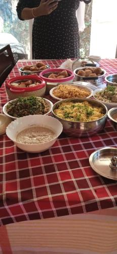 a table with bowls of food on a red and white checked table cloth at NIDHIVANA FARMS & RESORT, bakrebail-salethoor rd, Mangalore in Mangalore