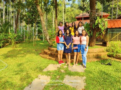 a group of women standing in front of a house at NIDHIVANA FARMS & RESORT, bakrebail-salethoor rd, Mangalore in Mangalore