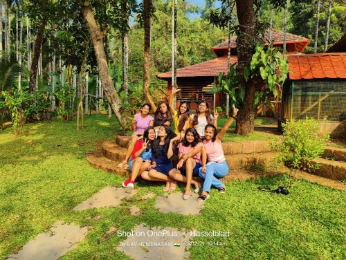 a group of women posing for a picture in front of a house at NIDHIVANA FARMS & RESORT, bakrebail-salethoor rd, Mangalore in Mangalore