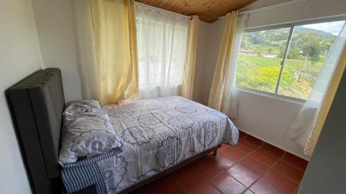 een kleine slaapkamer met een bed en een raam bij Cabaña Mi Terruño in Cogua