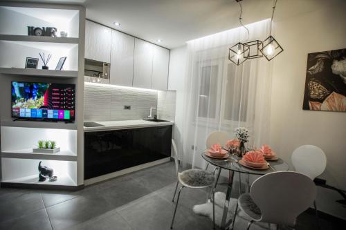 a kitchen and dining room with a table and a tv at KoVeL apartmani - Termalna Rivijera in Bogatić