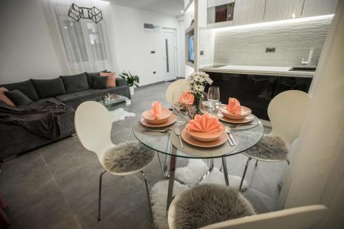 - un salon avec une table, des chaises et un canapé dans l'établissement KoVeL apartmani - Termalna Rivijera, à Bogatić