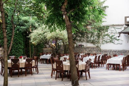 a dining area with tables and chairs and trees at Hotel Afa in Pristina